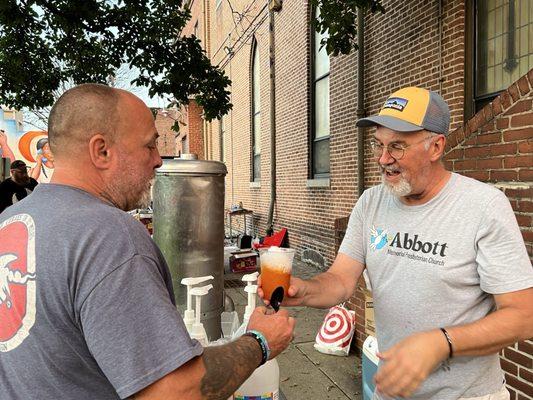 A man servers a snowball to another man at an outdoor party