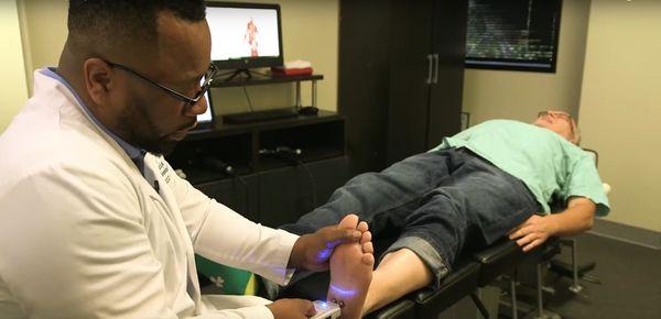 Dr. Britton using the peripheral nerve simulator which runs electricity through the nerves to reduce inflammation