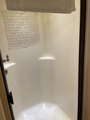 Clean walk-in shower with bronze hardware