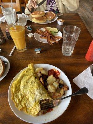 Omelette with Swiss cheese, mushrooms, tomatoes and onions with breakfast potatoes. Crispy bacon, fluffy pancakes.  All were delicious!