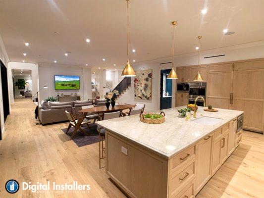 This open concept kitchen was designed tastefully with a 75" TV, 4 in ceiling speakers, and both can & pendant smart tunable lighting. Call