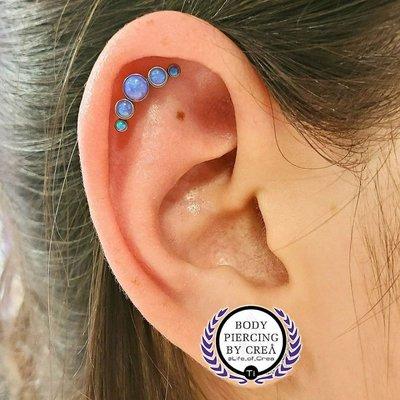 Helix piercing with titanium opal cluster. Body Piercing by Crea