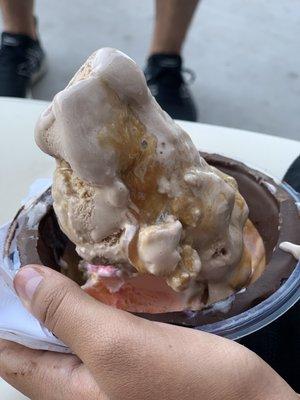 Cotton candy ice cream and chocolate malt with caramel in a chocolate covered waffle cone bowl