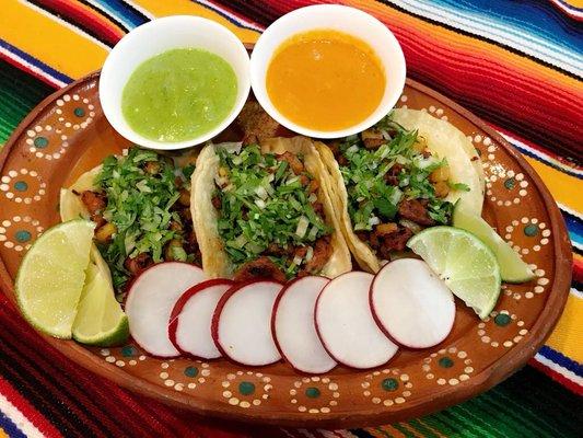 Tacos Al PASTOR ! Get your choice of green or red hot sauce .