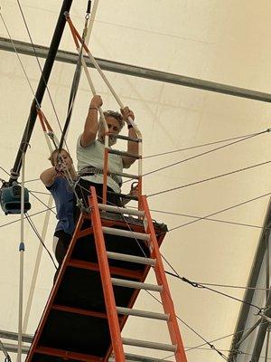 My husband at the top of the trapeze getting harnessed in for the flying