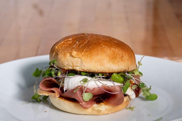 Burrata, prosciutto, micro greens and fig jam on brioche roll.