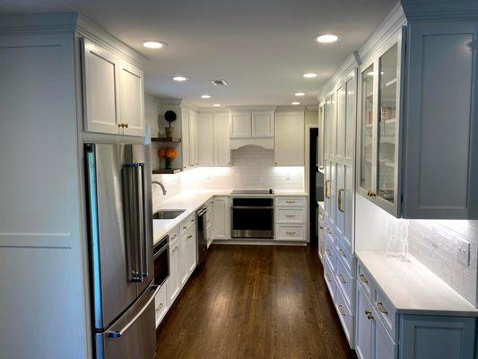 White shaker kitchen with dark hardwoods.