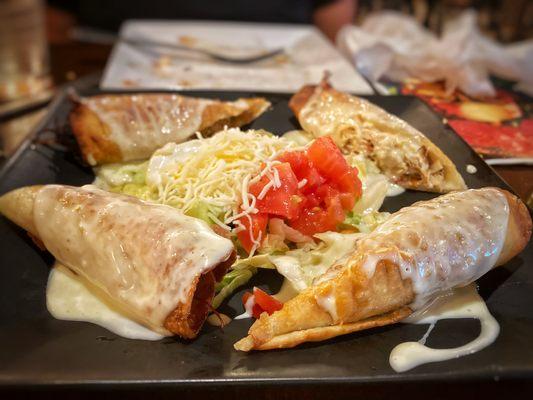 Mini Chimichangas smothered with creamy cheese. They split chicken and meat, two each.