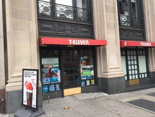 A small awning marks the spot of this small and narrow 7-Eleven.