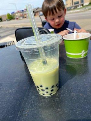 Pistachio boba tea with oat milk and a cutie in the background