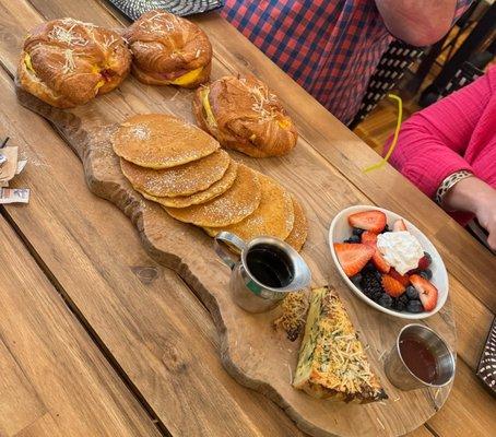 Breakfast sandwiches, pancakes, fruit, and quiche.