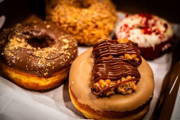 Front: Maple Raised with Churros
 Left: Nutella Raised
 Background: Roasted Coconut Raised & Red Velvet Cake