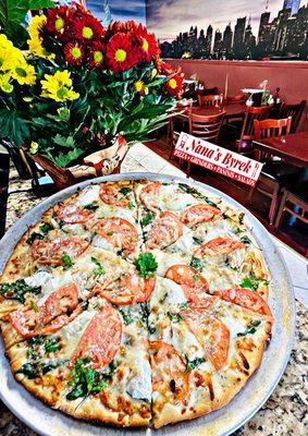 White spinach pizza with grilled chicken and sliced tomato