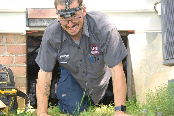 Fallon coming out of the crawlspace where the indoor unit was located.