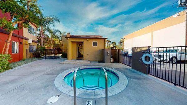 a small pool is in the middle of a house with a fence