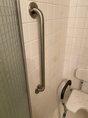 Grab bar installed inside shower to be used as a brace when stepping out over curb.