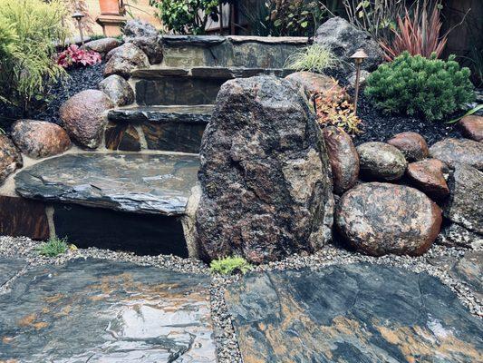 Irregular flagstone steps, boulders, planting and lighting