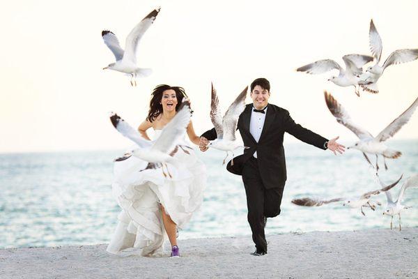 Bride and groom running on the beach