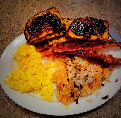 Scrambled eggs, fresh 'hash browns', bacon and raisin toast.