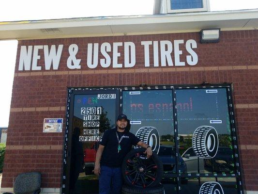 Jordi standing proud outside his tire shop.