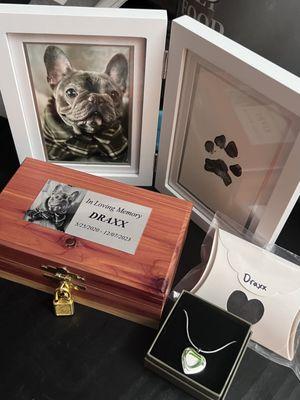 Cedar box, custom necklace with ash, paw print with frame, and container with lock of Draxx hair.