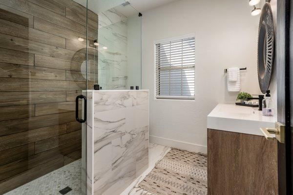 AFTER (removed linen closets and added a shower with beautiful wood looking tile to accent the marble tile)