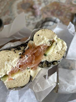 Black sesame bagel with lox, cucumbers, and capers