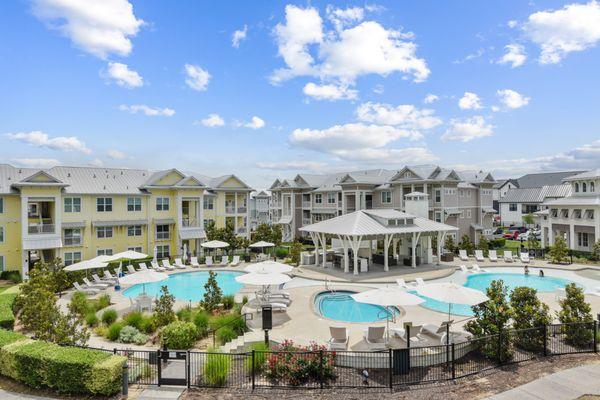 Pool area with trees, flowers, outdoor lounge and grill area, shallow pool, surrounded by Lantower Edgewater buildings