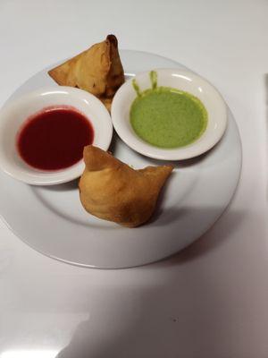 Samosas. Not sure what the sauces were but they were very good one was sweet one was spicy.