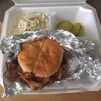 Pulled pork sandwich with blackberry sauce and a side of coleslaw.