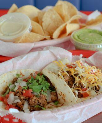 Soft flour tacos with a side of chips queso & guacamole