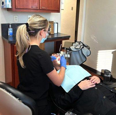 A dental hygienist working on a patient