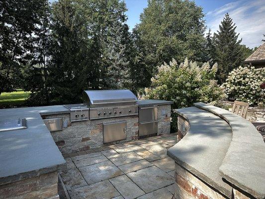 Beautiful outdoor kitchen and bar. Natural veneer stone & bluestone counterops.