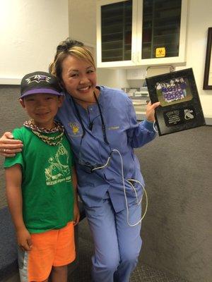 Dr. Thenard with one of our patients, who just happened to present us with a plaque for his Little League team we sponsored.