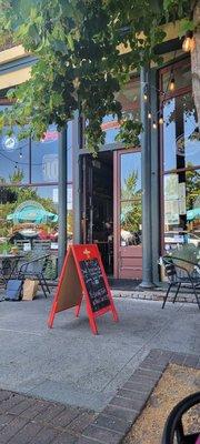 Front of restaurant. Shady tables on the sidewalk.