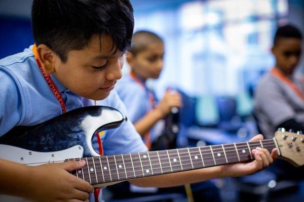 NYC Charter Schools Student Practicing Guitar in Class