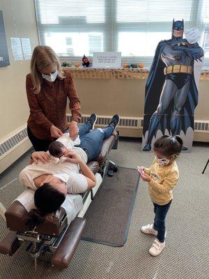 Newborns first chiropractic check up with big sister waiting her turn.