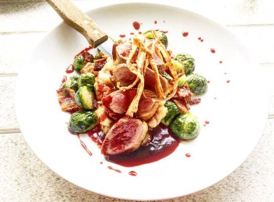 Roasted duck breast with pomegranate coulis, parsnip mash, and bacon brussel sprouts.