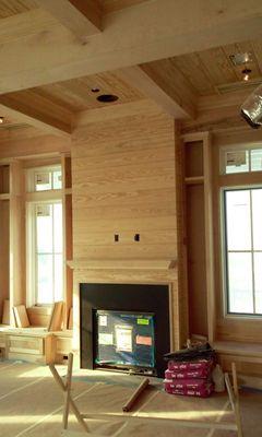 Custom designed & remodeled living room with fireplace, shiplap, faux beam ceiling, custom trim & half bench/hideaway storage under windows