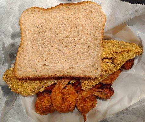 Two pieces of red snapper, four shrimp, sweet potato tots, and a slice of wheat bread