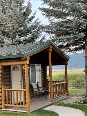 Cabin #5, porch with chairs and a stream behind the cabin