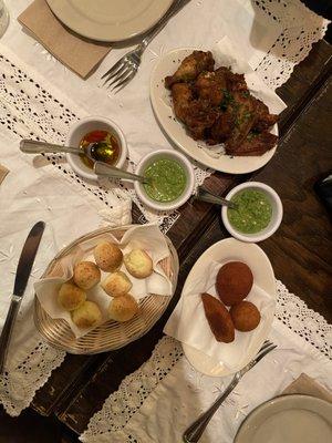 Chicken wings (top), pao de quejo cheese bread (bottom left), croquettes (bottom right)