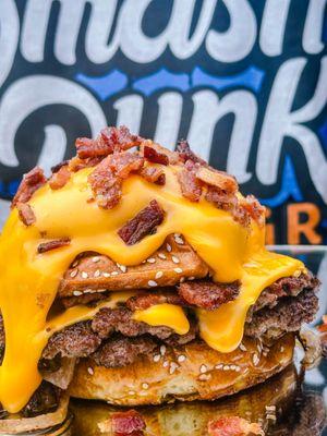 Lay up - two smashed patties smothered with cheddar sauce, chopped bacon, served on buttered sesame bun.