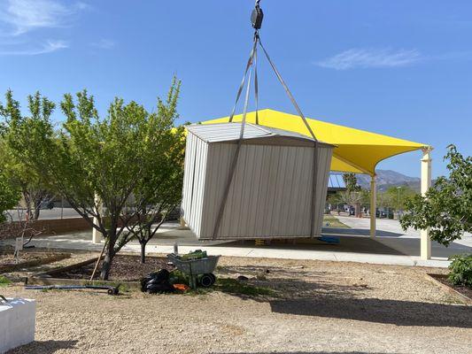 Small metal shed shed being moved.