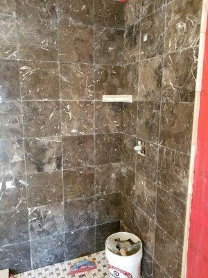 marble shower with stone shower floor tiles.