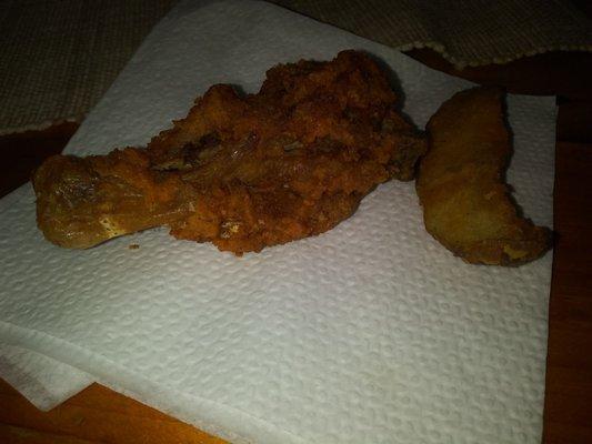 Dried up chicken leg next to mushy potato wedge