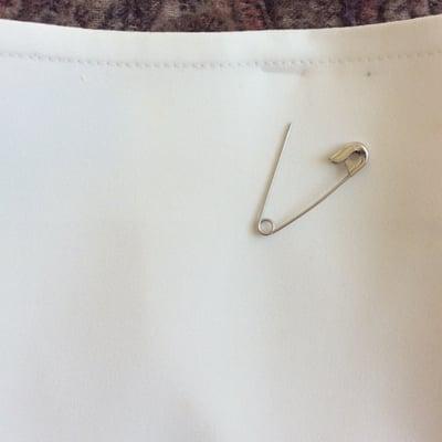 One of the safety pins used to hang my skirt. They left large gray holes. No bueno. And this is after being "fixed."