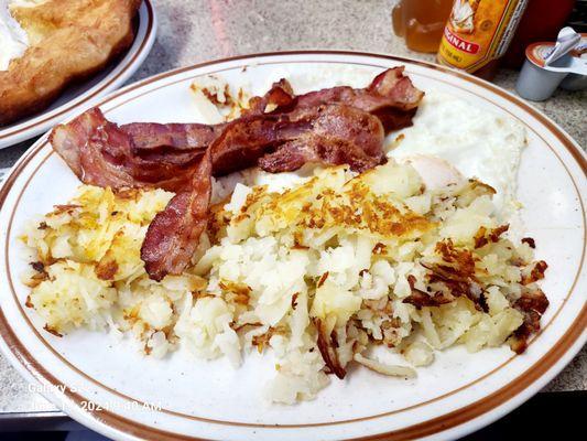 Eggs over easy, bacon, and Hashbrown