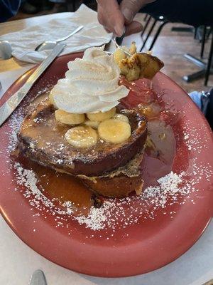 Banana Foster French toast with caramel Sauce and cinnamon whipped cream.