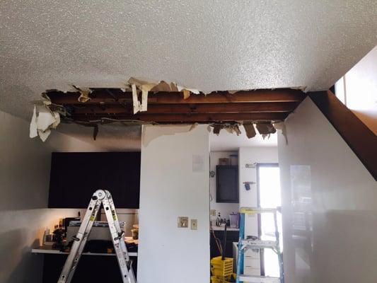 Water damage in living room ceiling from bathroom above.